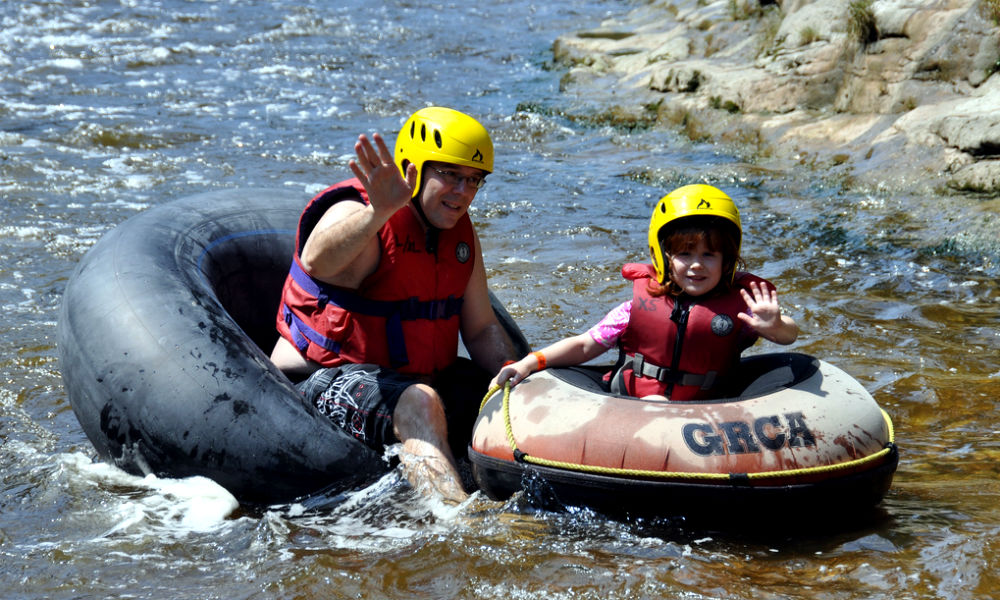 Adult and child tubing on rapids in Elora Gorge