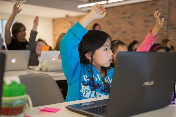 Girls raising hands at Girls Learning Code summer camp