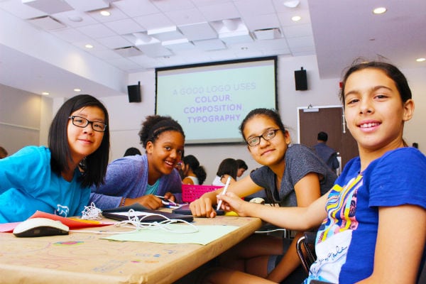 Four preteen girls smiling for camera at Girls Learning Code summer camp