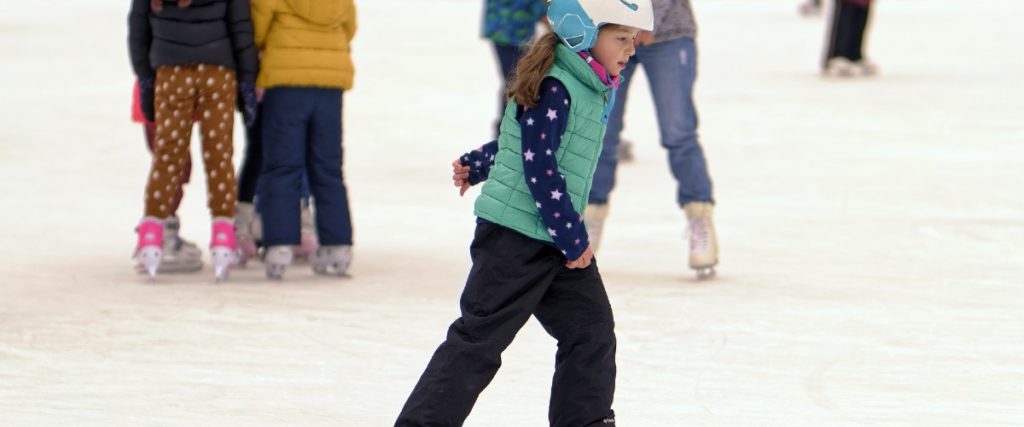 young girl skating on an outdoor ice rink