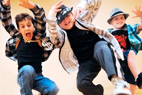 three young boys doing hip-hop moves facing camera