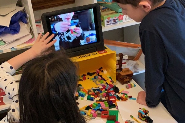 kids building with Lego and watching tablet at virtual Lego party