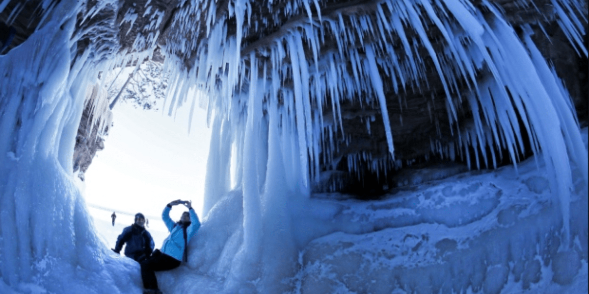 Couple sitting inside an ice cave at Apostle Islands National Lakeshore