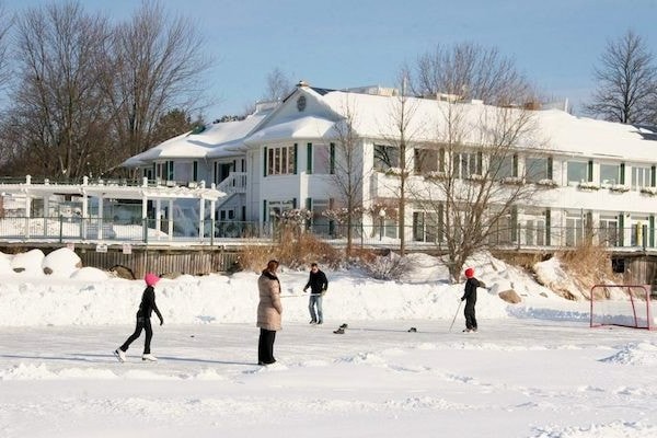 Family skating outdoors in front of Elmhirst's Resort inn